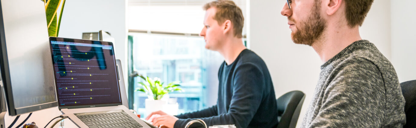 two men in office on computers